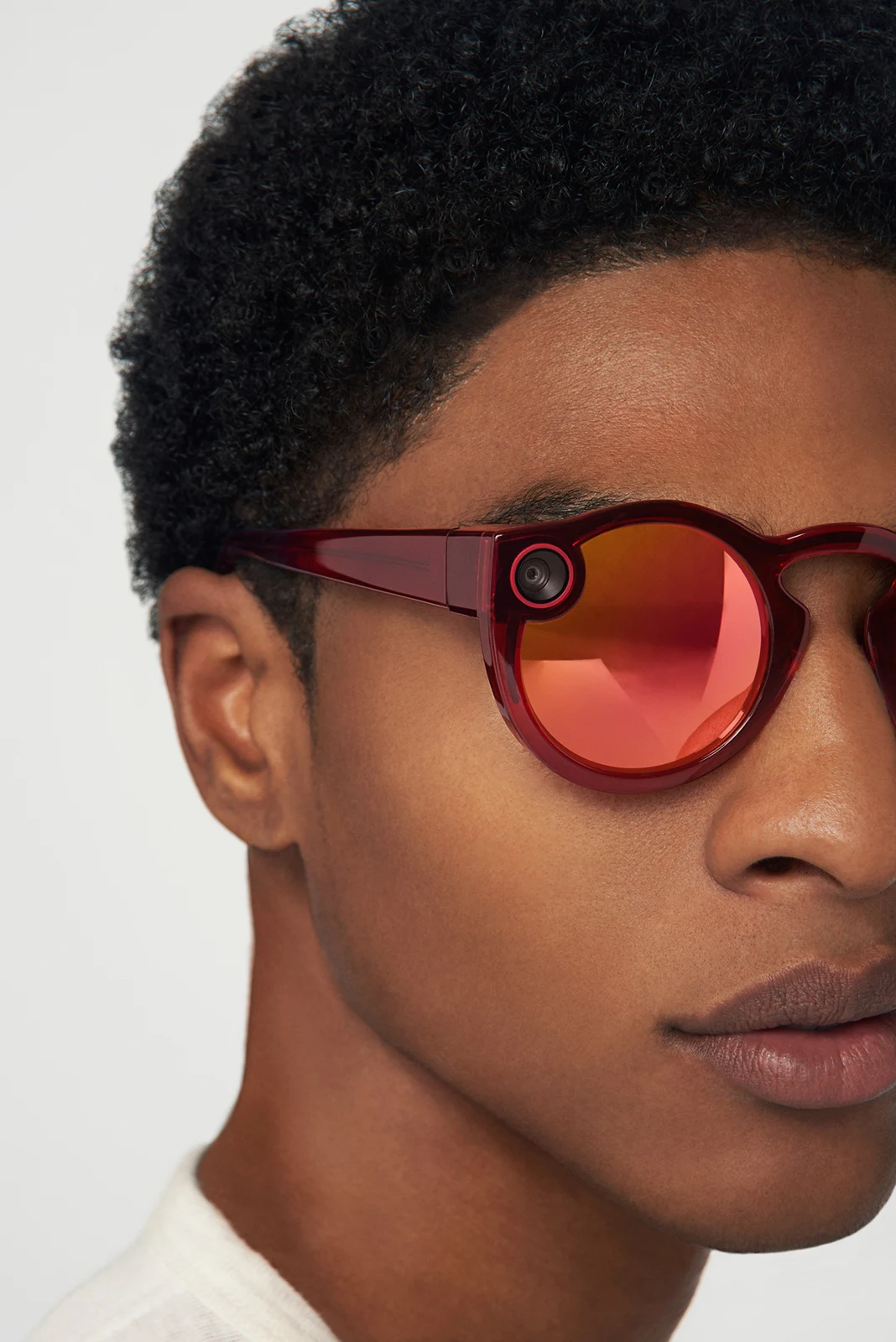 Close-up of red mirrored Spectacles and the frame’s camera detail.