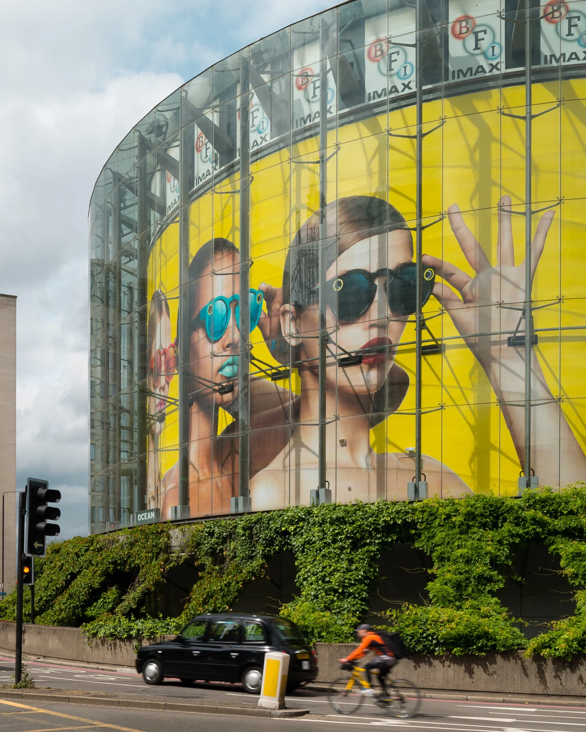 Spectacles campaign portraits covering a curved glass building.