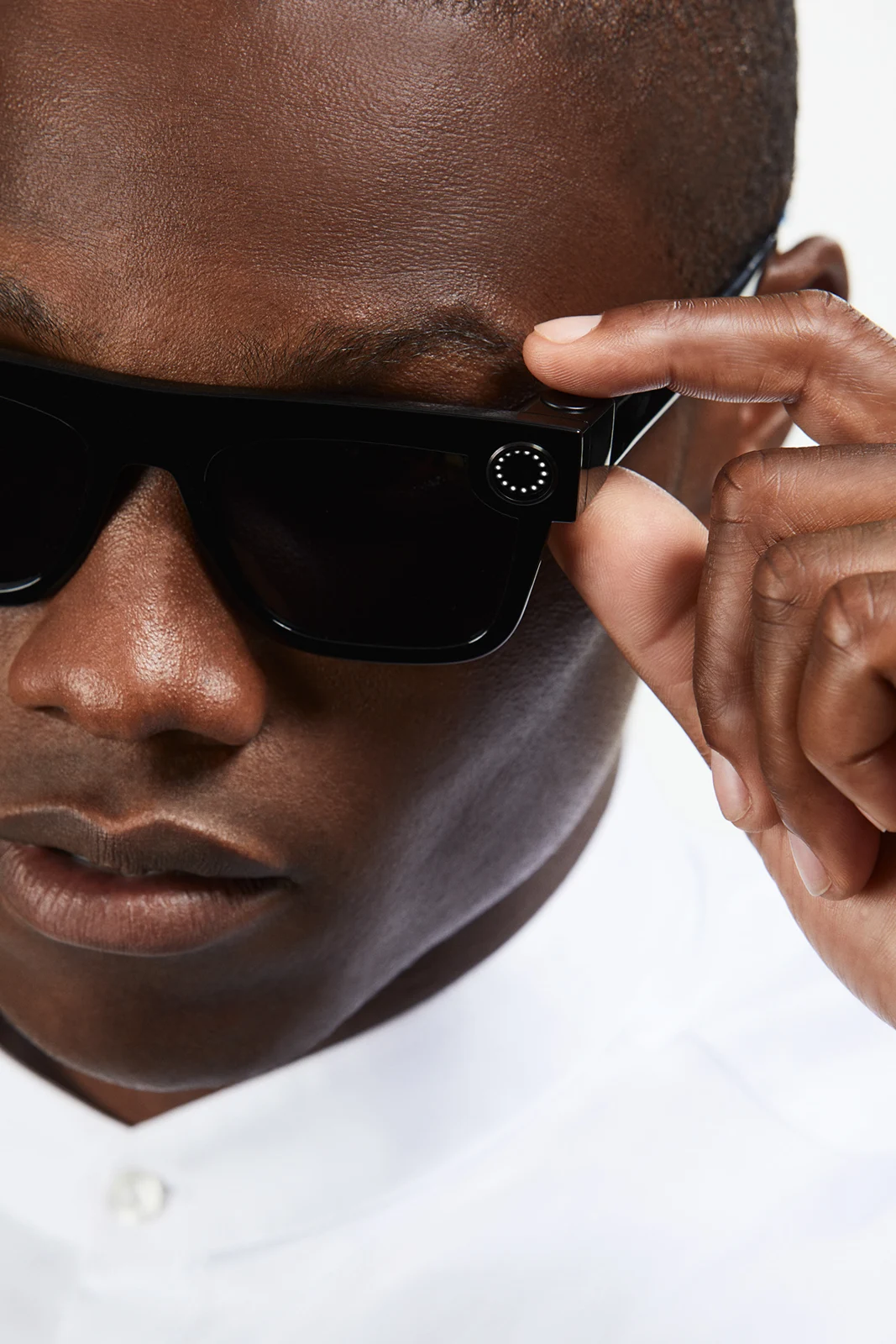Close-up of a model adjusting black Spectacles at the temple.