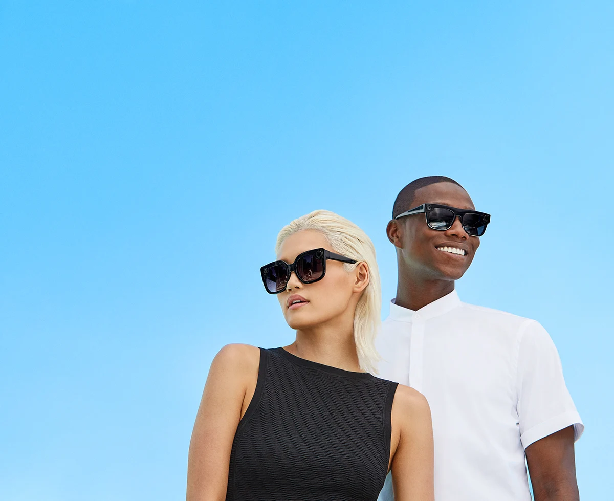 Two models in black Spectacles against a blue sky.