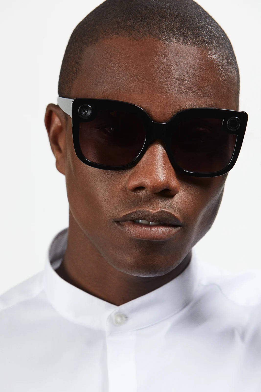 Front-facing studio portrait in black Spectacles and a white shirt.