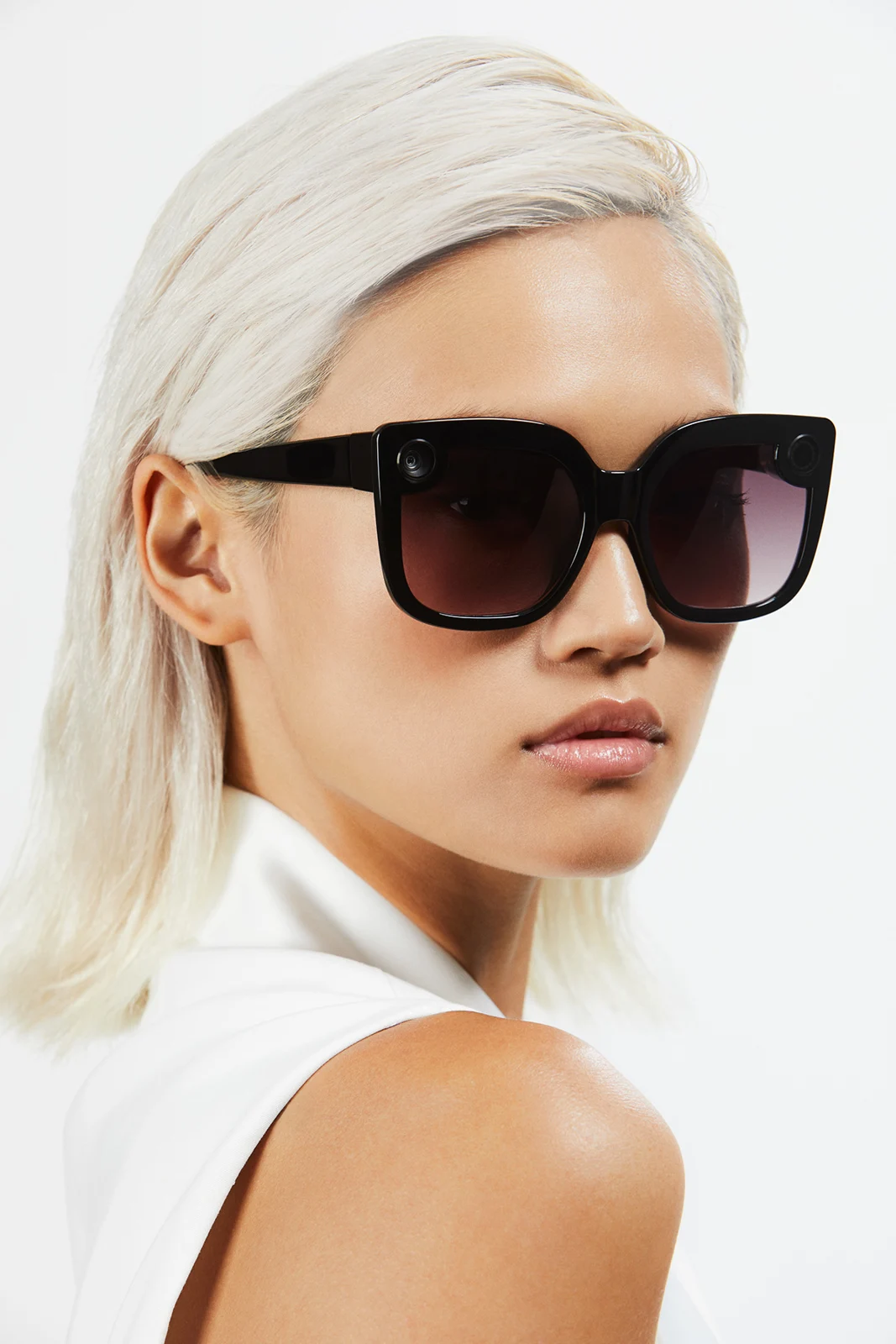 Model looking over one shoulder while wearing black Spectacles.