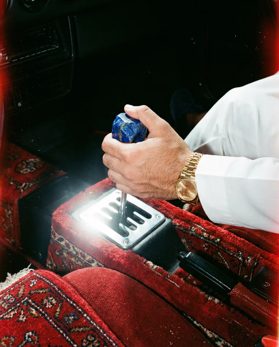 AI-generated image: A blue stone gearshift surrounded by red woven upholstery.