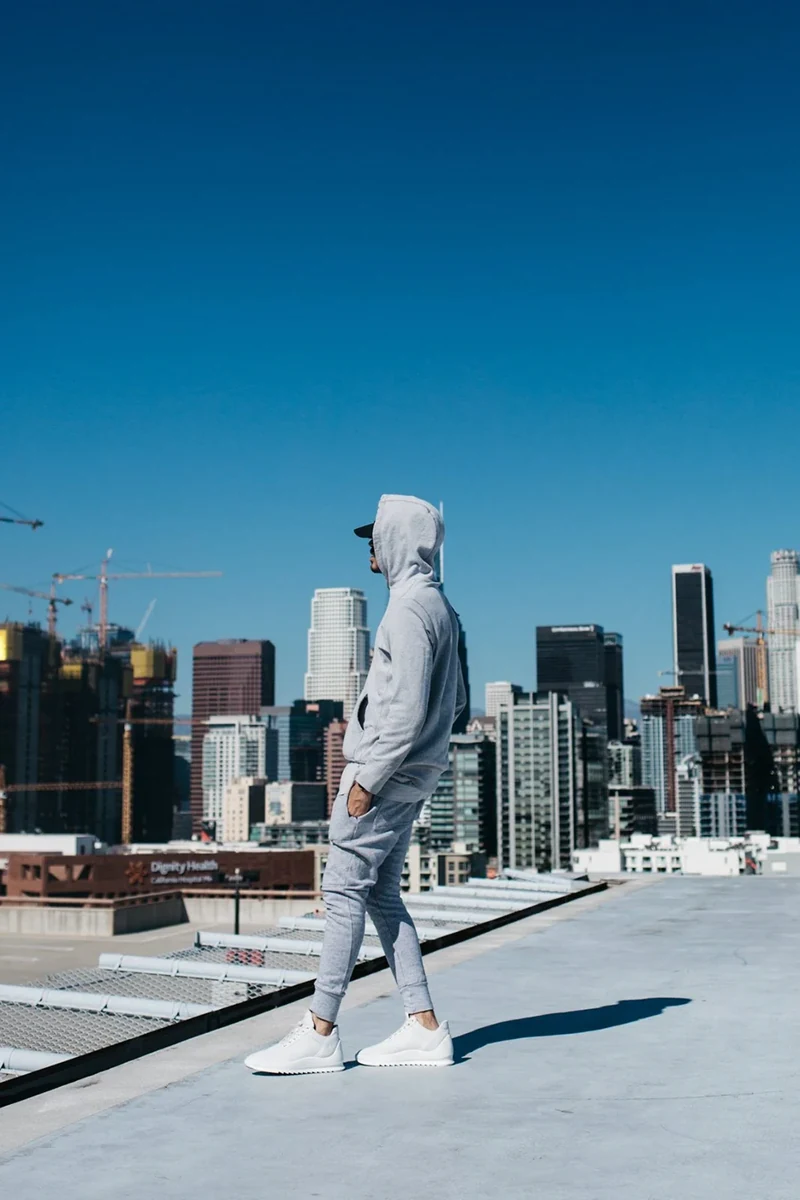 Model wearing pale sneakers on a Los Angeles rooftop.