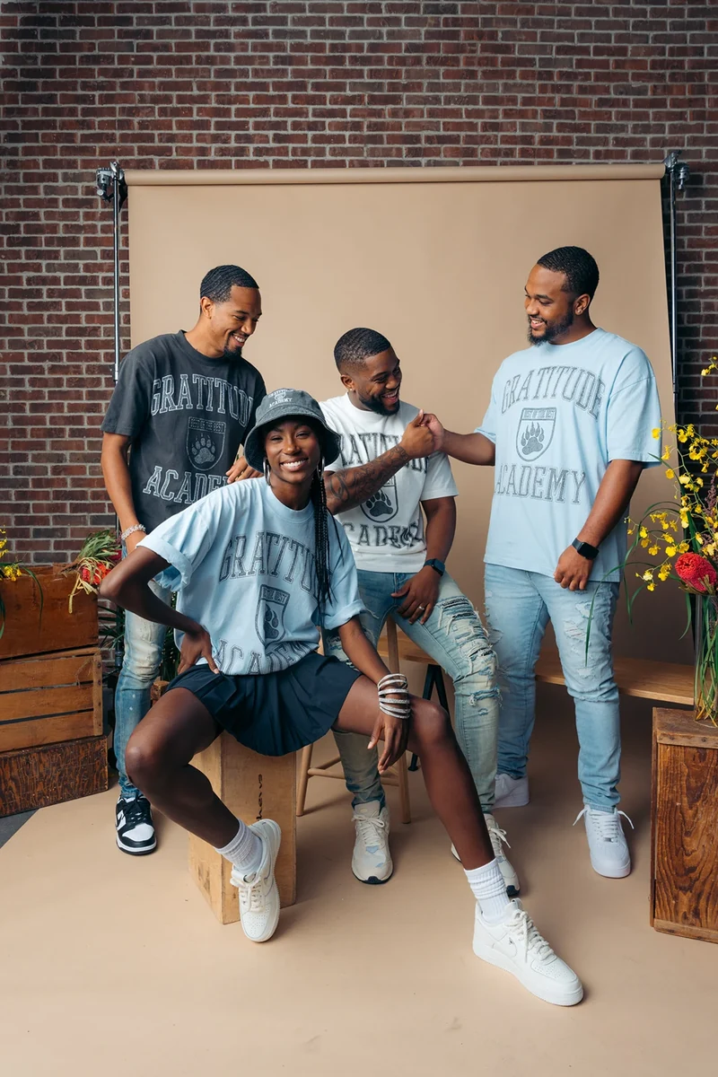 Four models interacting on the Gratitude Academy studio set.