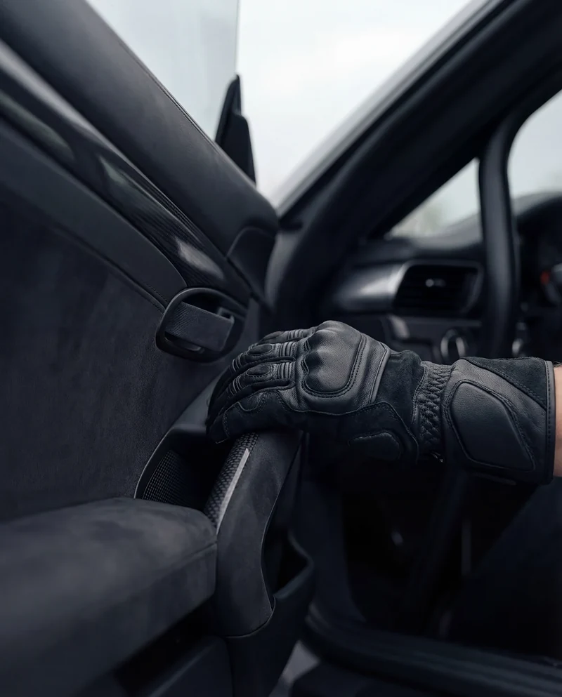 AI-generated gloved hand on the interior pull strap of a GT3 RS.