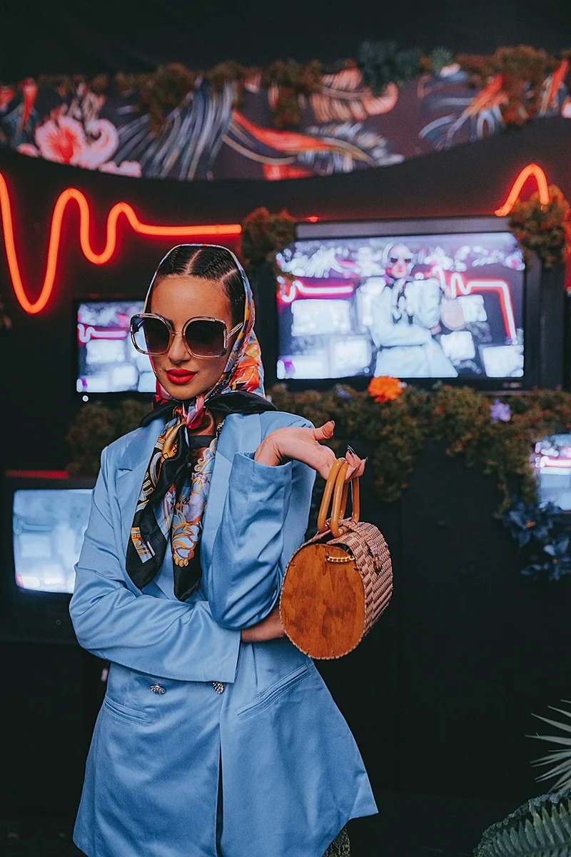 Portrait in blue tailoring with neon reflections behind the subject.