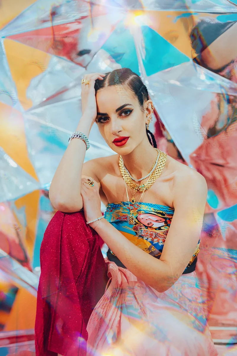 Seated fashion portrait surrounded by reflective panels.
