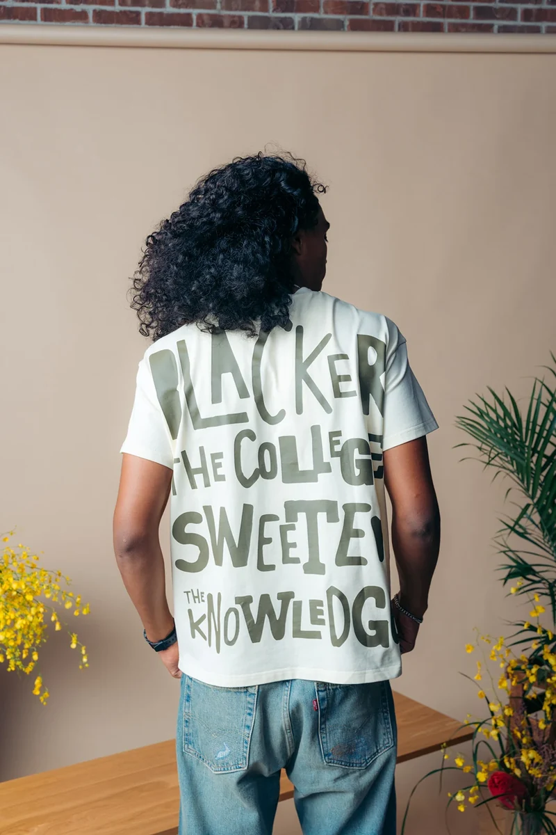 Rear view of oversized lettering on a white graphic tee.
