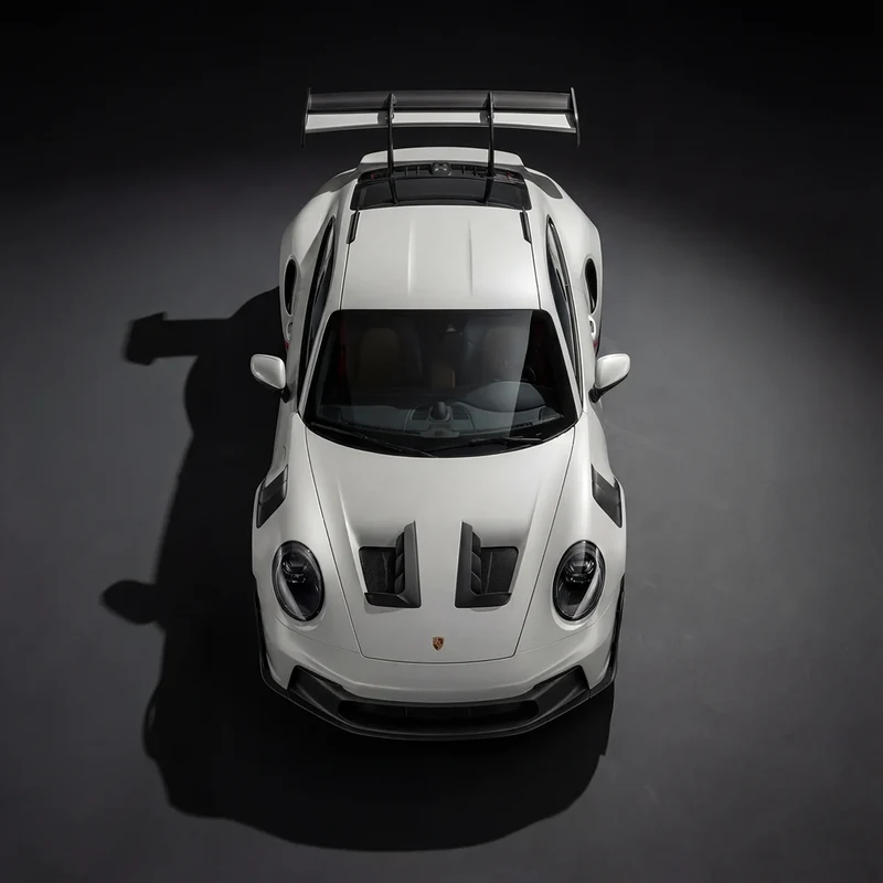AI-generated overhead view of a white Porsche 911 GT3 RS against a dark floor.