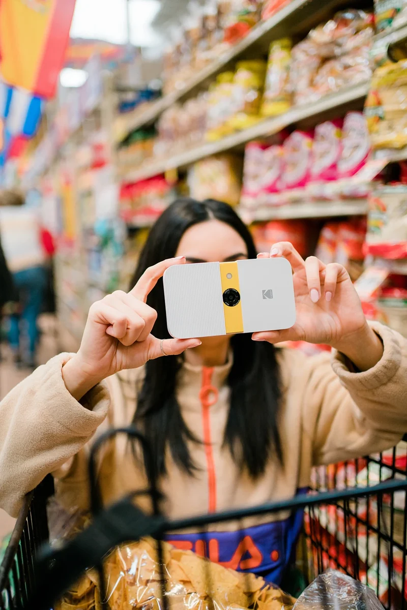 Lifestyle photograph of a Kodak instant camera in a grocery store.