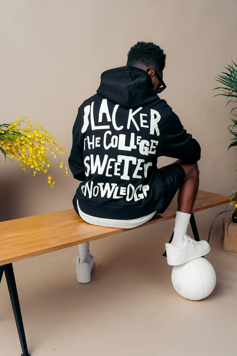 Rear view of a black tee with oversized hand-lettered graphics.