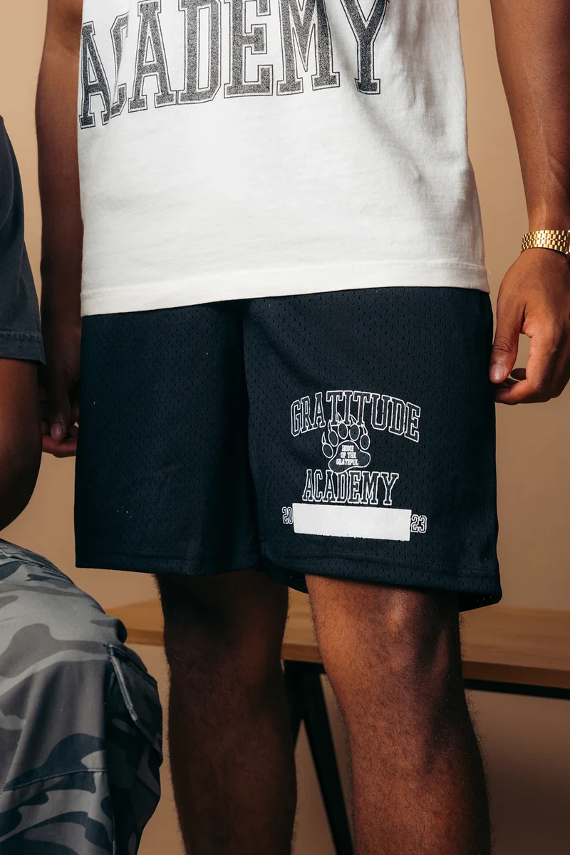 Close-up of the printed graphics on a white tee and black shorts.