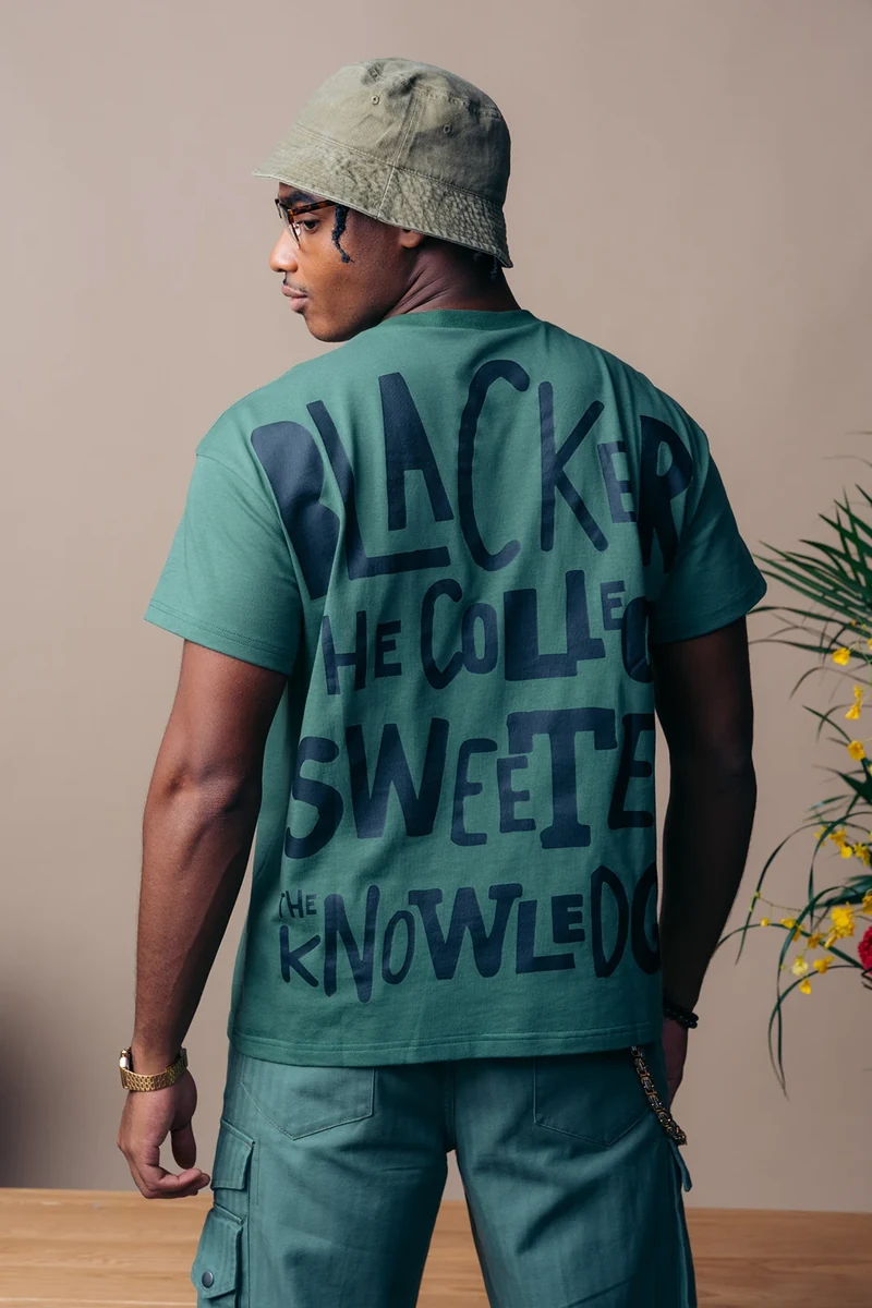 Rear view of hand-lettered graphics on a green tee.