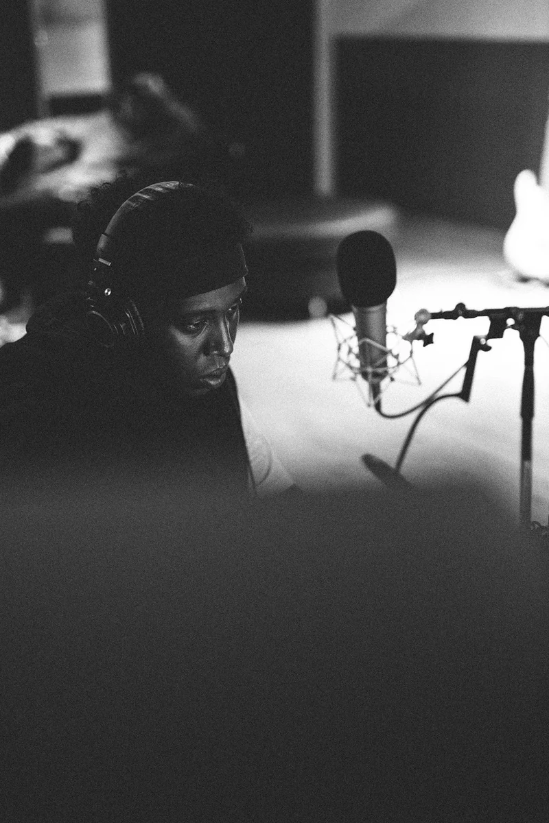 Monochrome close portrait of 451 beside a studio microphone.