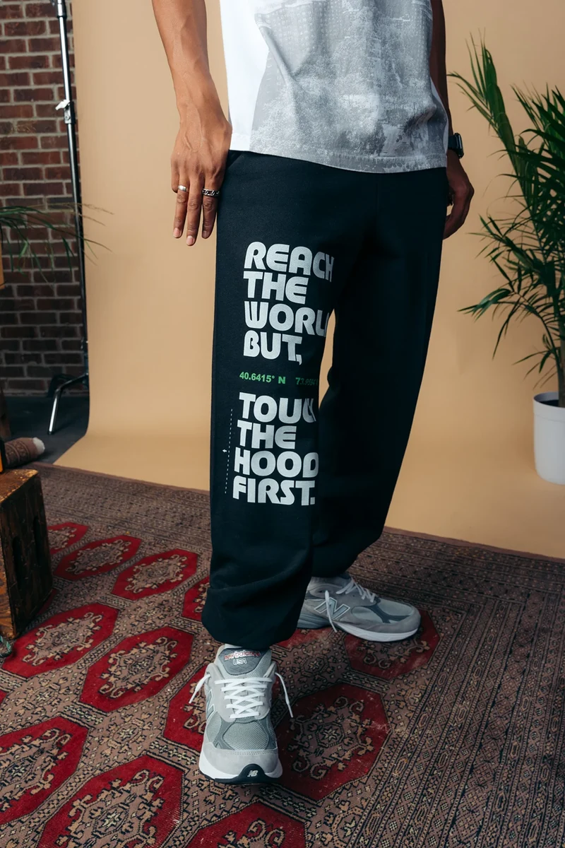 Printed trousers and sneakers on a patterned rug.
