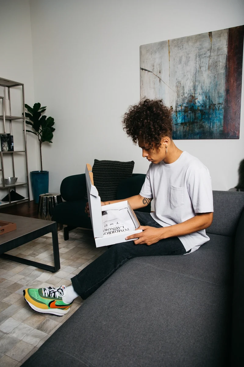 Model in a gray tee reading on a couch.