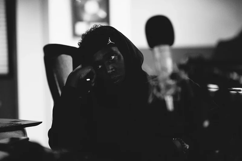 Grainy monochrome portrait of 451 seated in the recording studio.