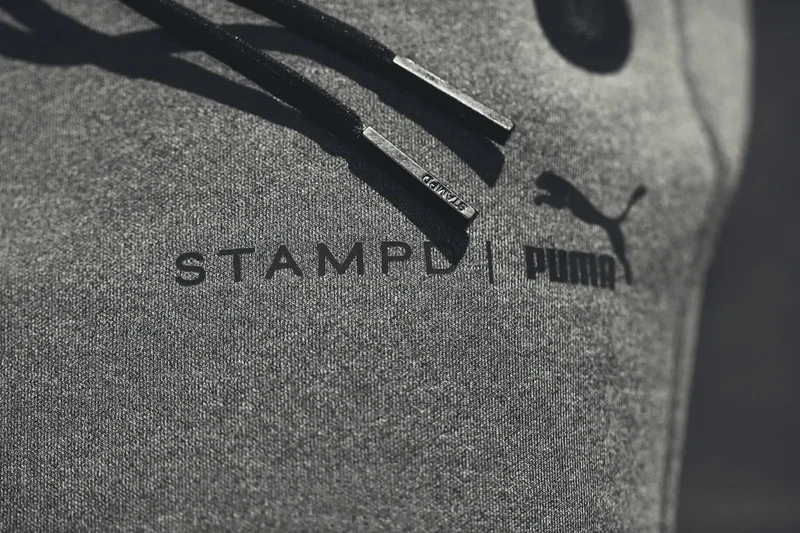 Close-up of the STAMPD × PUMA garment branding.