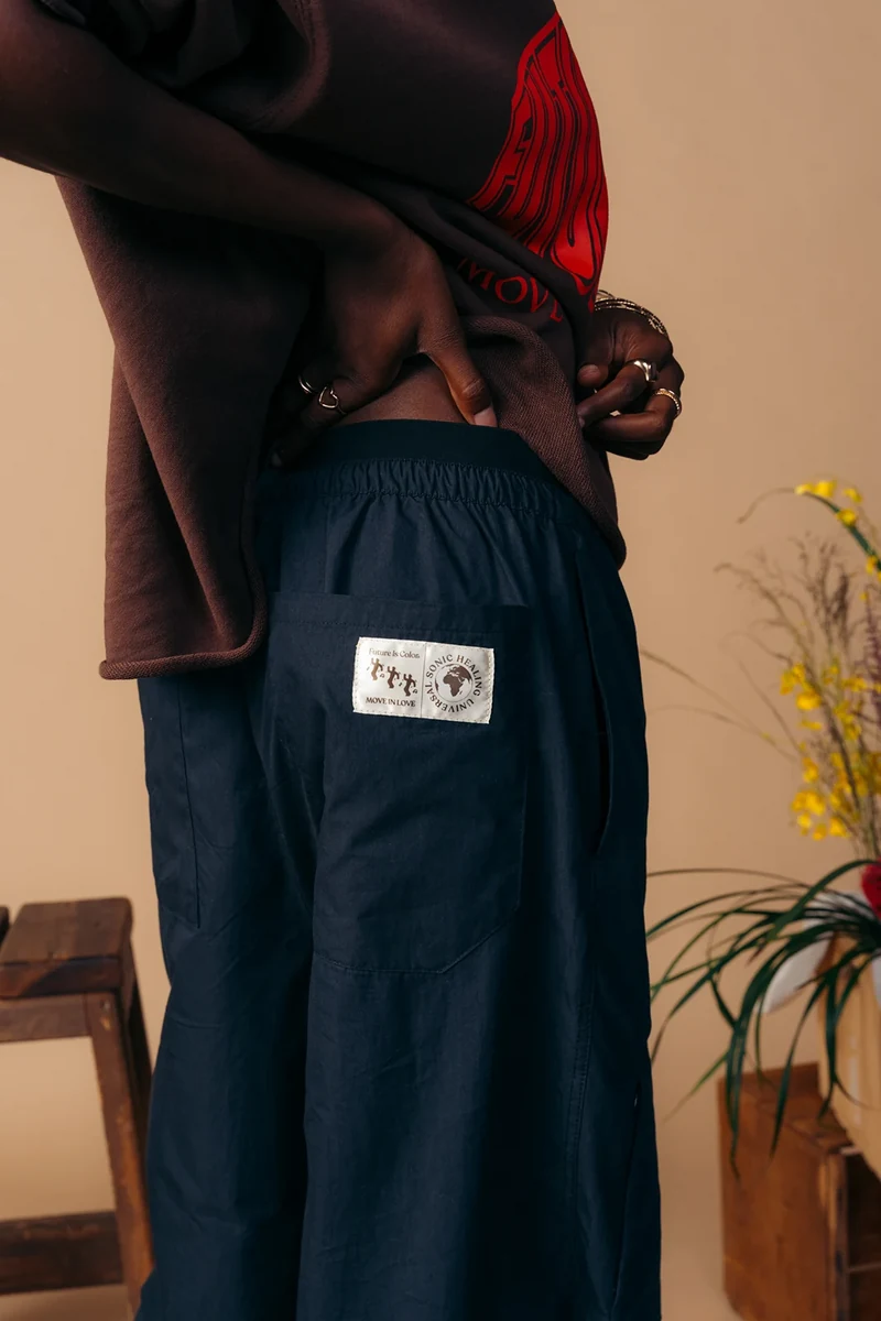 Close-up of a woven label on dark shorts beneath a graphic tee.