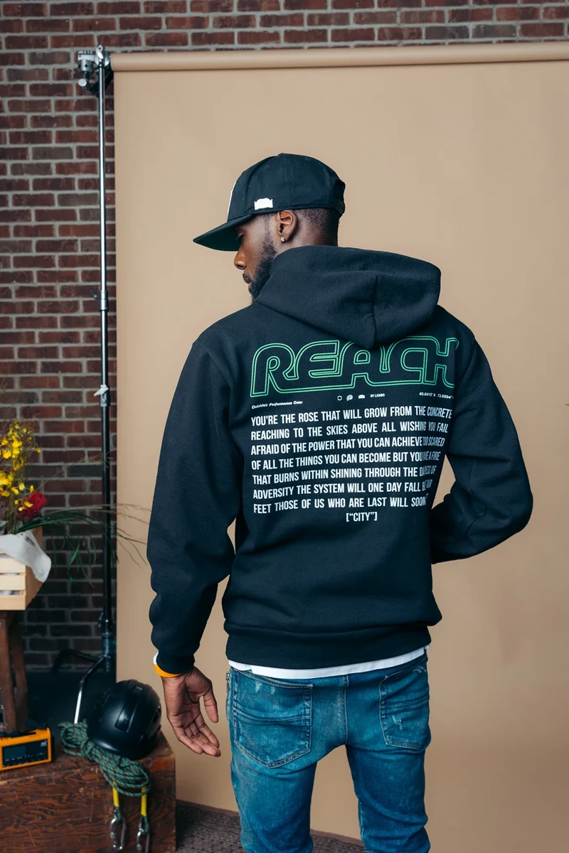 Rear view of a black hoodie, baseball cap, and jeans.