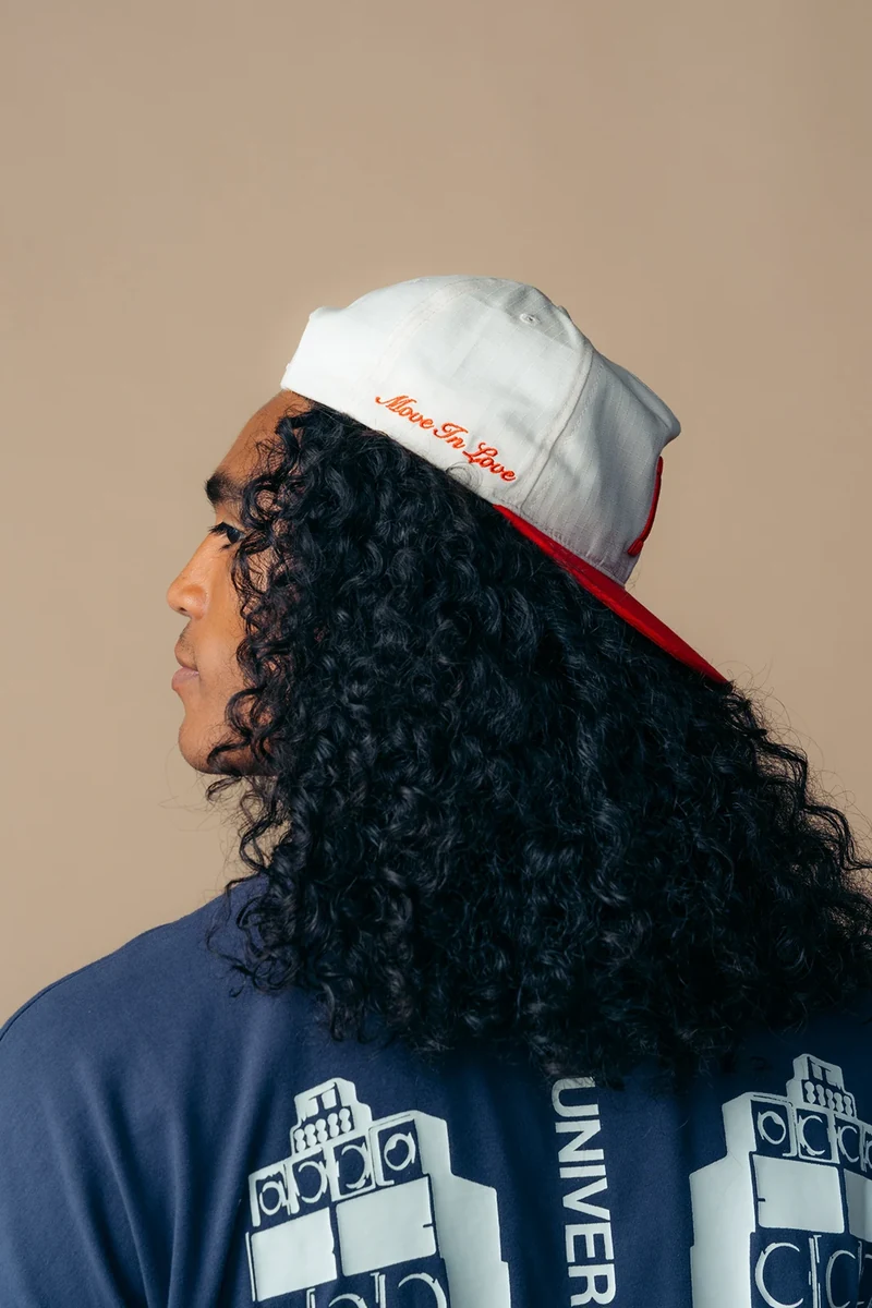 Close-up of a baseball cap and the back graphics on a navy tee.