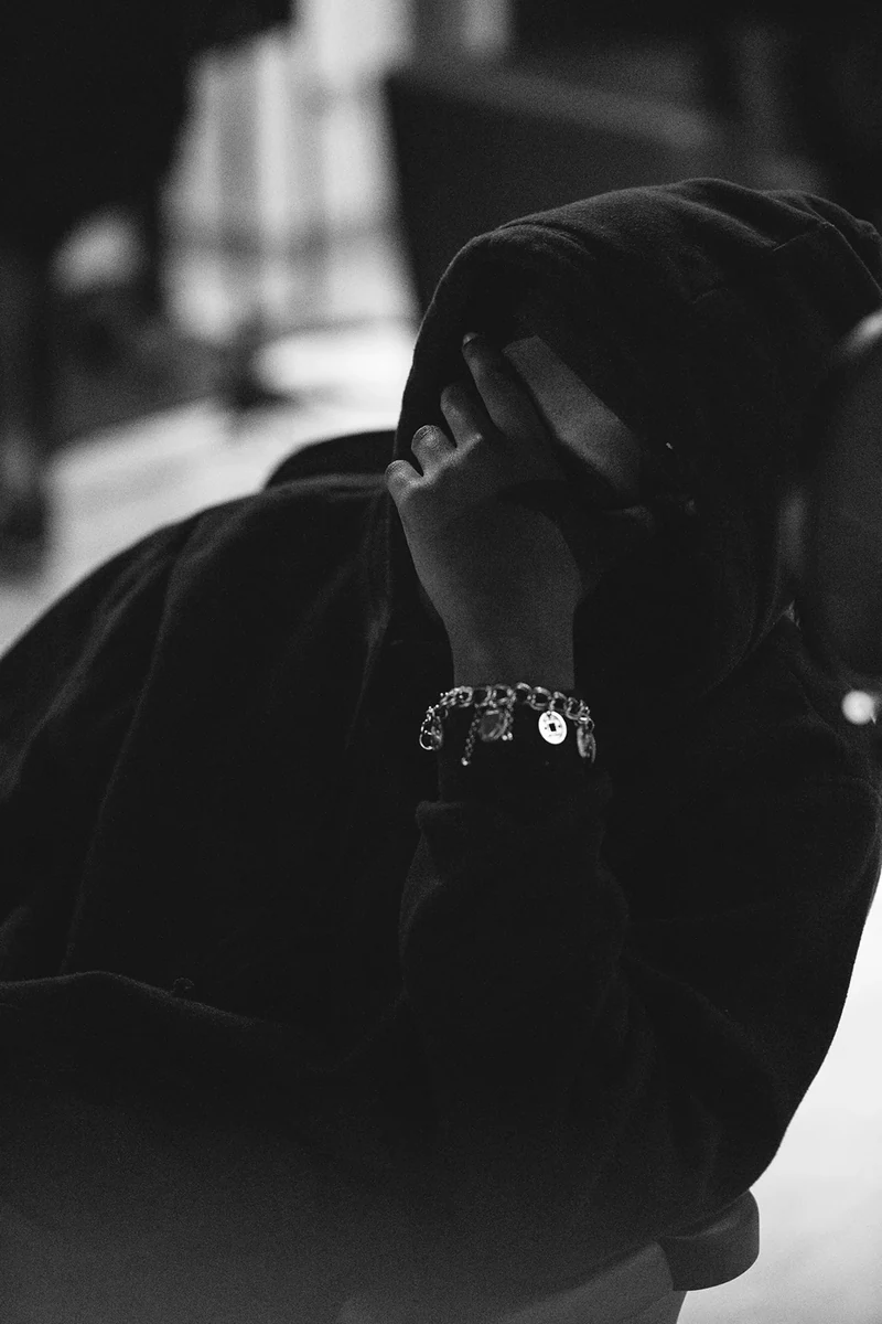Monochrome portrait of 451 with his hand over his face.