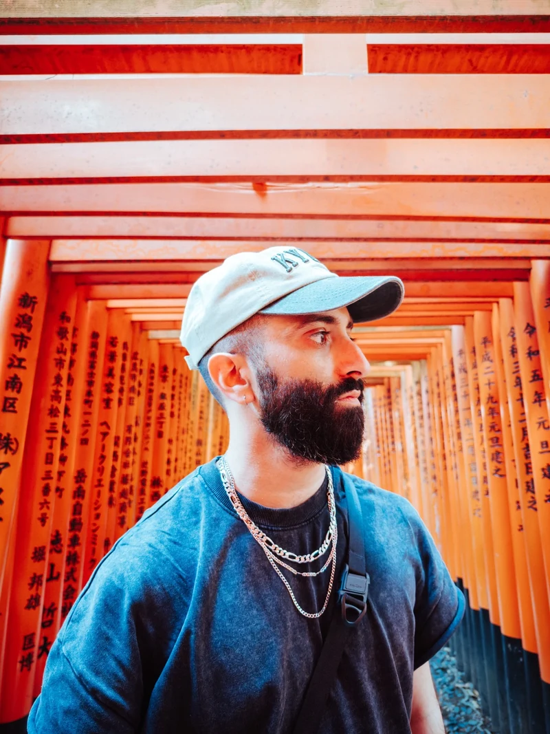 Faiz Ghori beneath the orange torii gates at Fushimi Inari in Kyoto