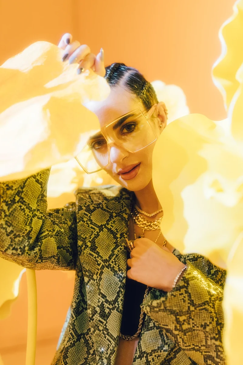 ZEOPATRA in snakeskin tailoring among yellow hanging shapes.
