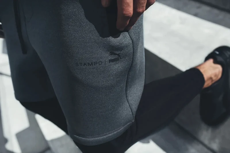 Top-down detail of gray STAMPD × PUMA shorts.
