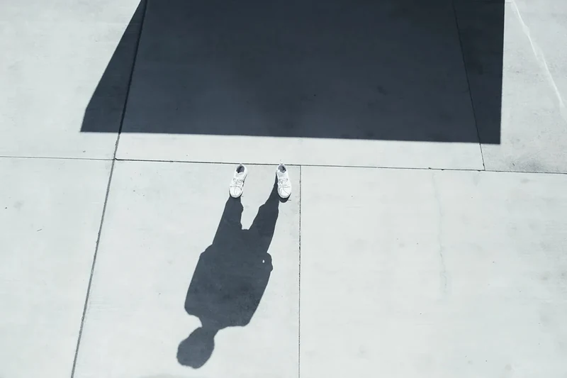 Overhead view of a model and long architectural shadows.