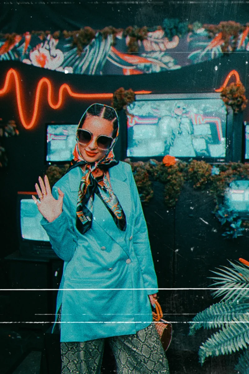 ZEOPATRA in blue tailoring inside a neon-lit room.